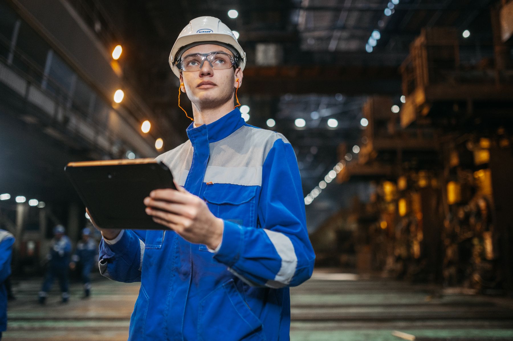 Tecnico con tablet durante un sopralluogo in uno stabilimento industriale